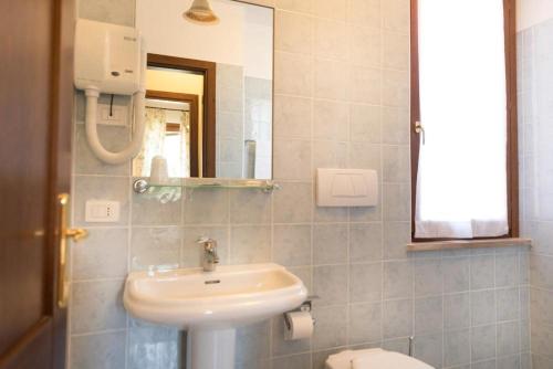 a bathroom with a sink and a toilet and a mirror at Agriturismo La Vecchia Fattoria in Orte