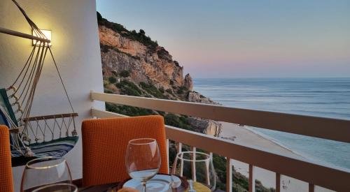 a balcony with a table with a view of the ocean at Sesimbra Sun&Sea - Beachfront Apartment! in Sesimbra