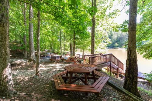 a picnic table and bench next to a lake at Our Neck of the Woods at Hidden Lake in Nebo