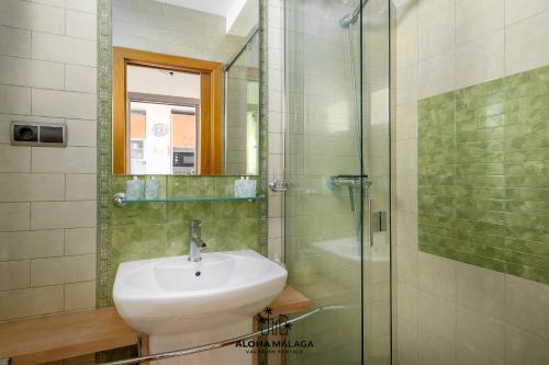 a bathroom with a sink and a glass shower at Lucila Beachfront Pedregalejo By AlohaMálaga in Málaga