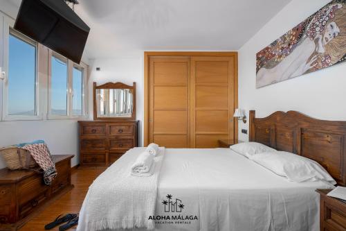 1 dormitorio con 1 cama grande y puerta de madera en Lucila Beachfront Pedregalejo By AlohaMálaga, en Málaga