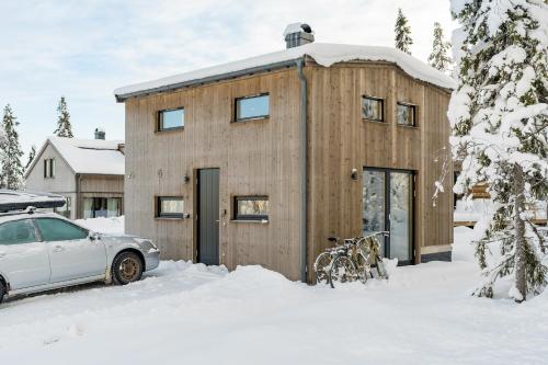 uma casa de madeira com um carro estacionado na neve em Mysig liten stuga perfekt för par eller liten familj em Sälen