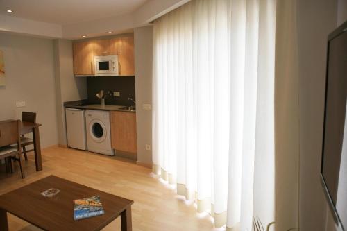 a living room with a large window with white curtains at Hotel Acapulco in Lloret de Mar