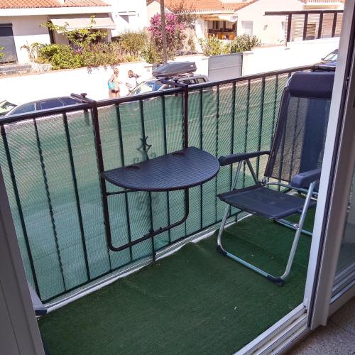 een tafel en stoelen op een balkon met een zwembad bij Appartement T2 lumineux, moderne avec parking et wifi - 4SABLE16 in Canet-en-Roussillon