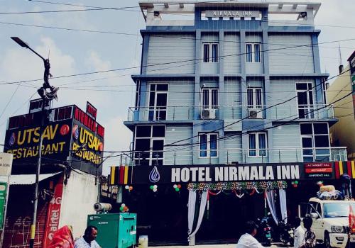 a tall building with a hotel in india at Hotel Nirmala Inn in Jamūi