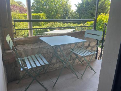 uma mesa e duas cadeiras sentadas numa varanda em La Bulle em Châlons-en-Champagne