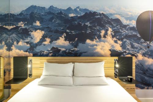 a bedroom with a bed with a mountain mural at Novotel Leeds Centre in Leeds