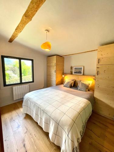 une chambre avec un grand lit et une fenêtre dans l'établissement Chalet familial Saint-Gervais, à Saint-Gervais-les-Bains