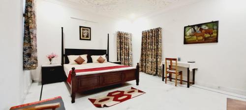 um quarto com uma cama e uma secretária. em Colonels Homestay em Udaipur