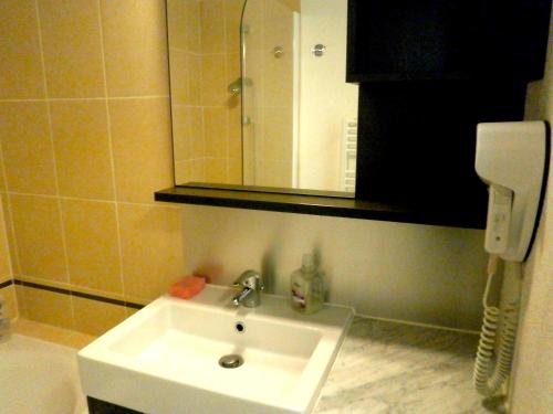 a bathroom with a white sink and a mirror at Studio au cœur de Valberg à proximité des pistes in Valberg