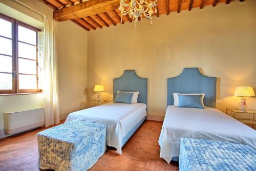 ein Schlafzimmer mit zwei Betten und einem Kronleuchter in der Unterkunft Casa Lionardo by PosarelliVillas in Vinci