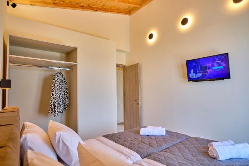 a bedroom with a bed and a tv on the wall at Olive grove villa in Plátonas
