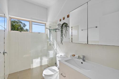ein weißes Badezimmer mit Toilette und Waschbecken in der Unterkunft Seaspray - 93 Tramican Street in Point Lookout