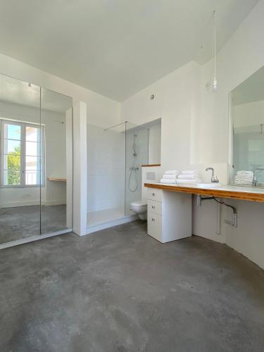 une salle de bain blanche avec un lavabo et des toilettes dans l'établissement Maison d’hôtes Le 1853, à Narbonne