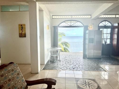 a living room with an open door to a patio with the ocean at Stunning Apartment castle comfort in Roseau
