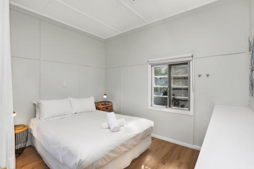 a white bedroom with a bed and a window at Blue Waters in Point Lookout
