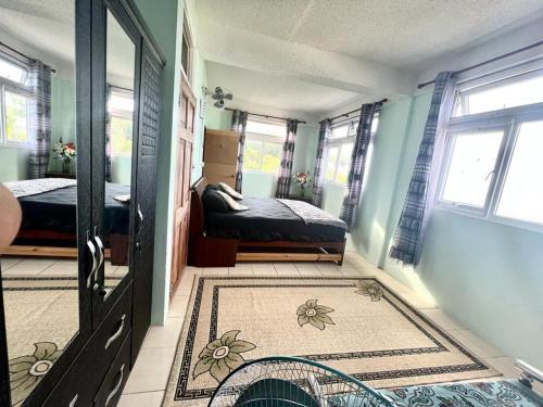 a room with two beds and a door with a rug at Stunning Apartment castle comfort in Roseau