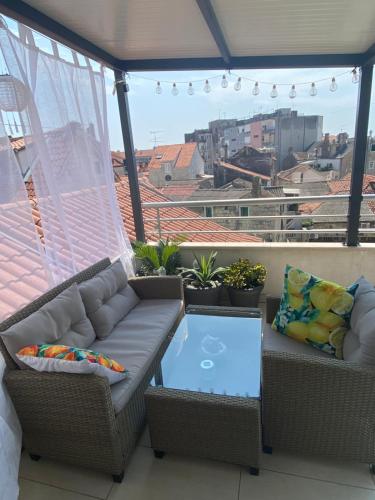 a balcony with a couch and a glass table at Apartment Dome in Split