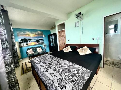 a bedroom with a black and white bed and a shower at Stunning Apartment castle comfort in Roseau