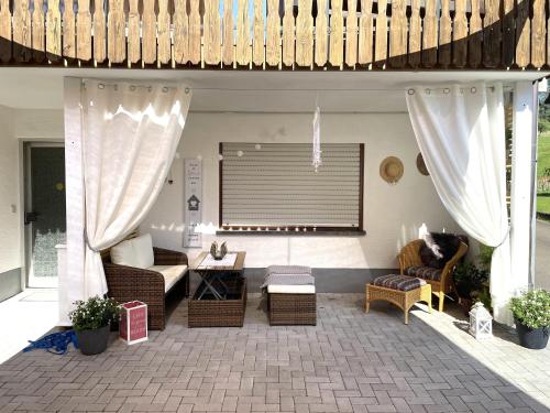 a patio with wicker chairs and a living room at Morgensonne in Gutach im Breisgau