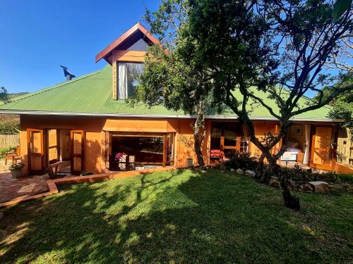 una casa con techo verde y patio en Milky Way: Home with large garden, firepit & stars, en Kenton on Sea
