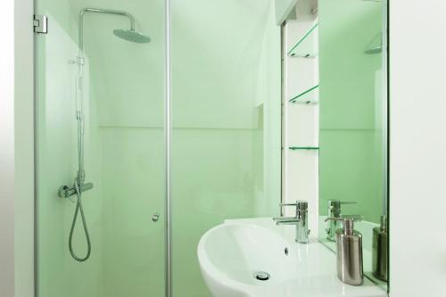 a white bathroom with a sink and a shower at Casa Campari in Ostuni