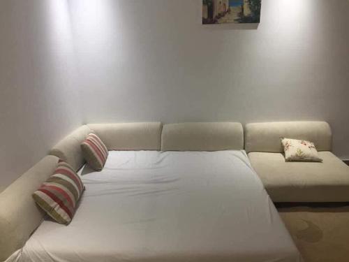 ein weißes Sofa mit Kissen darauf im Zimmer in der Unterkunft maison d'hôte familiale للعائلات فقط in Sousse
