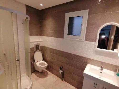 ein Bad mit einem WC, einem Waschbecken und einem Fenster in der Unterkunft maison d'hôte familiale للعائلات فقط in Sousse
