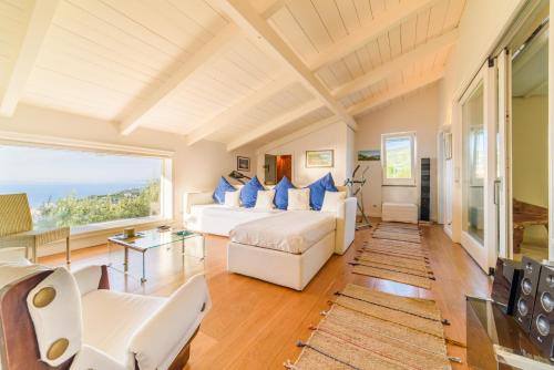 a living room with white furniture and a large window at Estate4home - Villa Maria Rosaria in Massa Lubrense