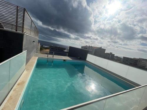 a swimming pool on the roof of a building at Kriol Guest House in Praia