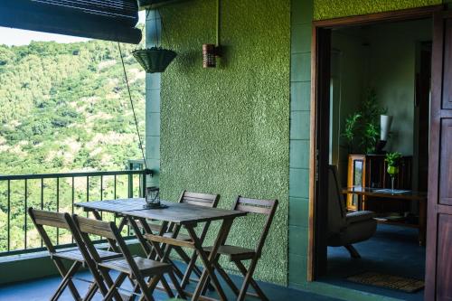einen Tisch und Stühle auf dem Balkon eines Hauses in der Unterkunft The Green Shack in Quatre Soeurs