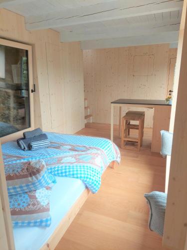 a small room with a bed and a table at HERZLI-CHALET über dem Rheintal mit Schlossblick in Werdenberg