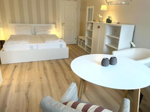 a bedroom with a bed and two tables and chairs at Landhaus am Meer - Whg 5 Hilligenlei in Utersum