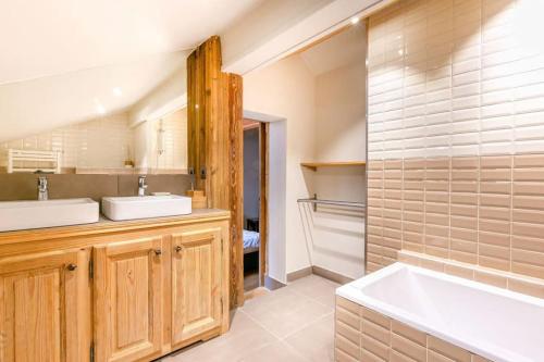 a bathroom with two sinks and a bath tub at Chalet NANOUK in Le Joseray