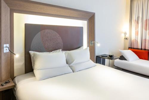 a hotel room with a large bed with white pillows at Novotel Leeds Centre in Leeds