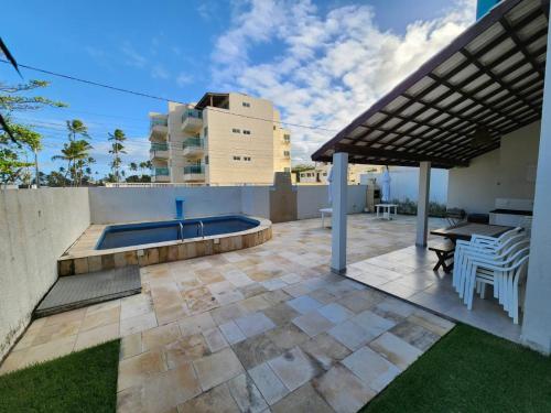 a patio with a table and a swimming pool at Mahalo Beach Residence in Porto De Galinhas