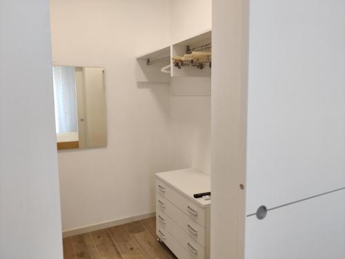 a white kitchen with a cabinet and a drawer at Casa Mikaela sea view in Vieste