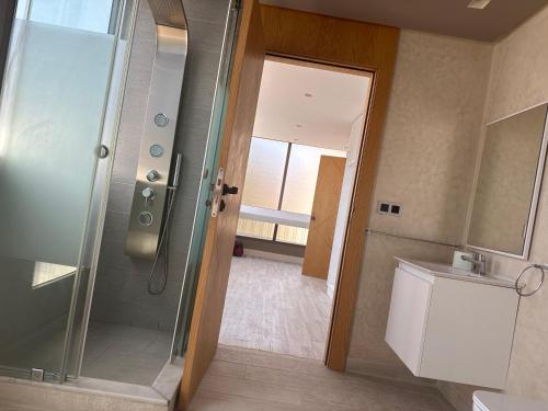 uma casa de banho com um chuveiro, um WC e um lavatório. em Luxurious apartment em Tânger
