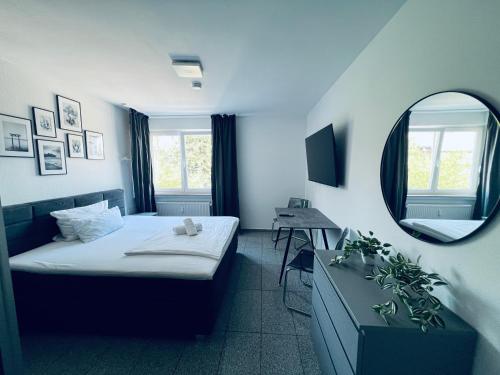 a small room with a bed and a mirror at Lipp Apartments in Cologne