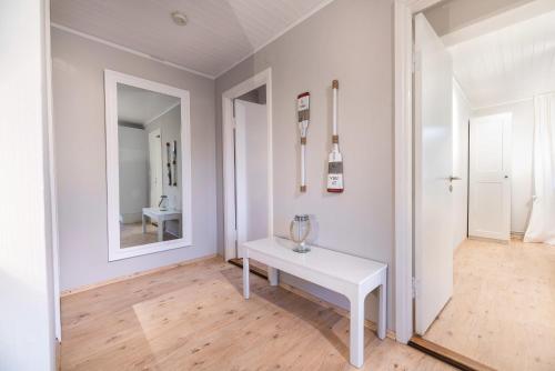 a white room with a white table and a mirror at Landhaus am Meer - Whg 4 Rungholtsand in Utersum