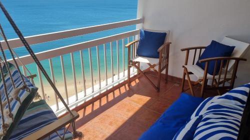 a room with a balcony with a view of the ocean at Sesimbra Sun&Sea - Beachfront Apartment! in Sesimbra