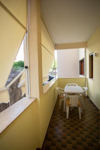 a room with a table and chairs and a window at Agio Apartments Diamante - Bilocale in Diamante