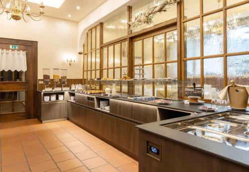 una cocina grande con una línea de buffet en un restaurante en G. Hotel Des Alpes (Classic since 1912), en San Martino di Castrozza