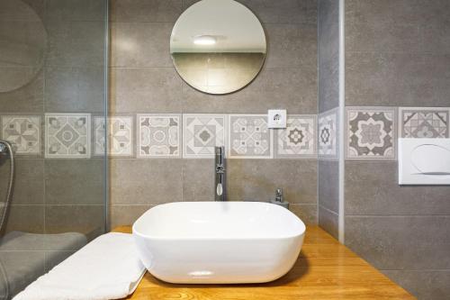 een badkamer met een witte wastafel en een spiegel bij Apartmani PORTO in Golubac