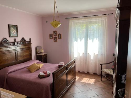 a bedroom with a bed with purple sheets and a window at Villa Franca in Castelluccio Inferiore