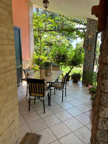 a patio with a table and chairs and trees at Villa Franca in Castelluccio Inferiore