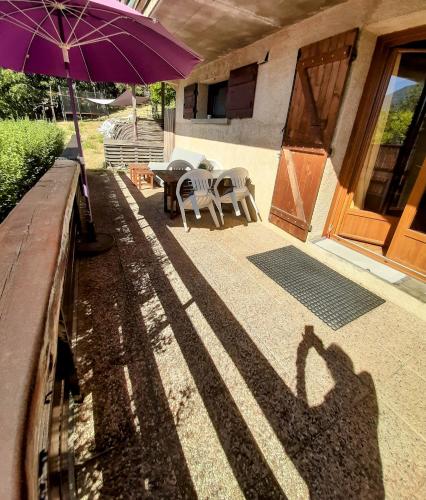 a shadow of a person holding a purple umbrella at Studio sympa avec terrasse , maxi 4 pers.Briançon in Briançon