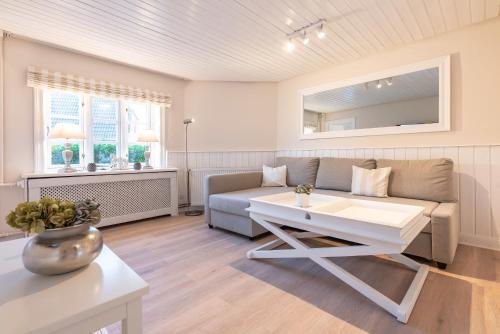 a living room with a couch and a table at Landhaus am Meer - Whg 1 Norderaue in Utersum