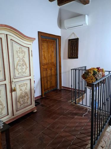 a hallway with a door and stairs with flowers on a table at Corte Ramedello in Cerea