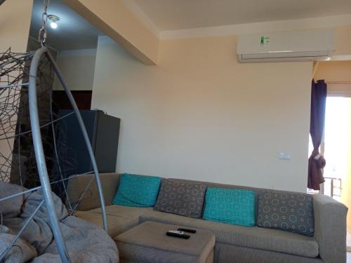 uma sala de estar com um sofá com almofadas azuis em استوديو عائلات فقط الساحل الشمالي ريتال فيو em Al Ḩammām